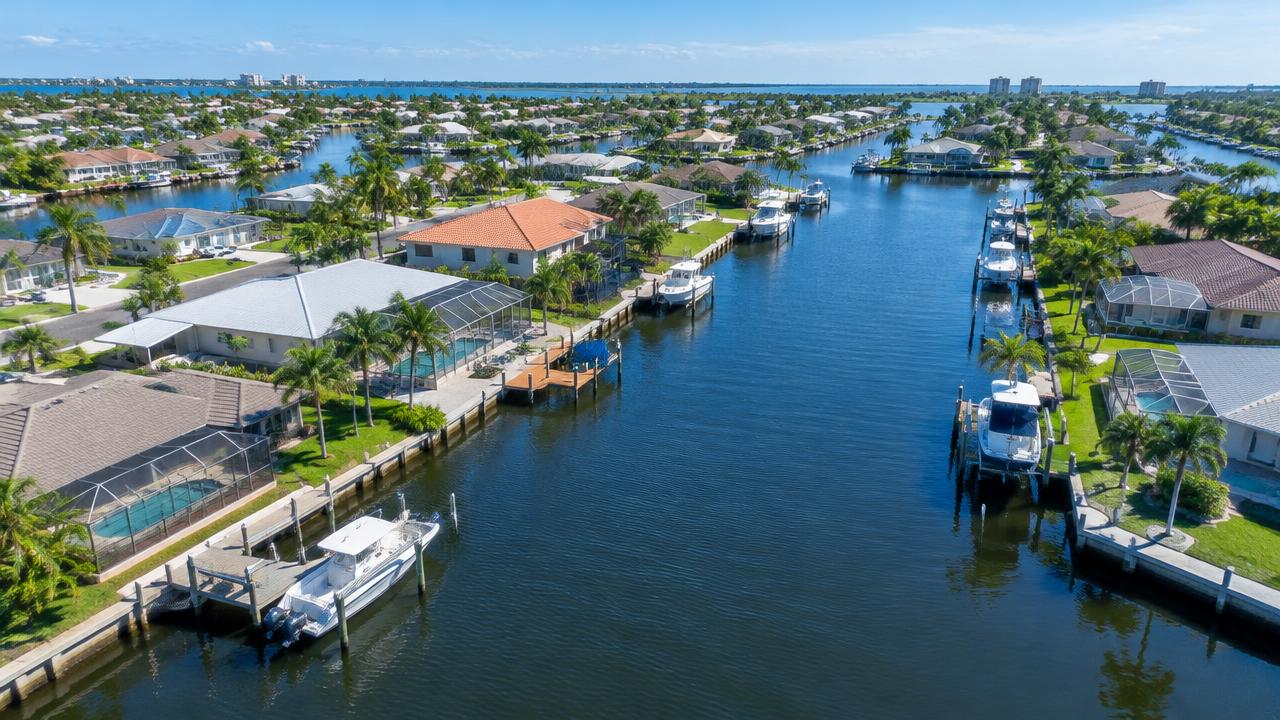 Aerial view of canal-front homes with boats and docks in Cape Coral, Florida