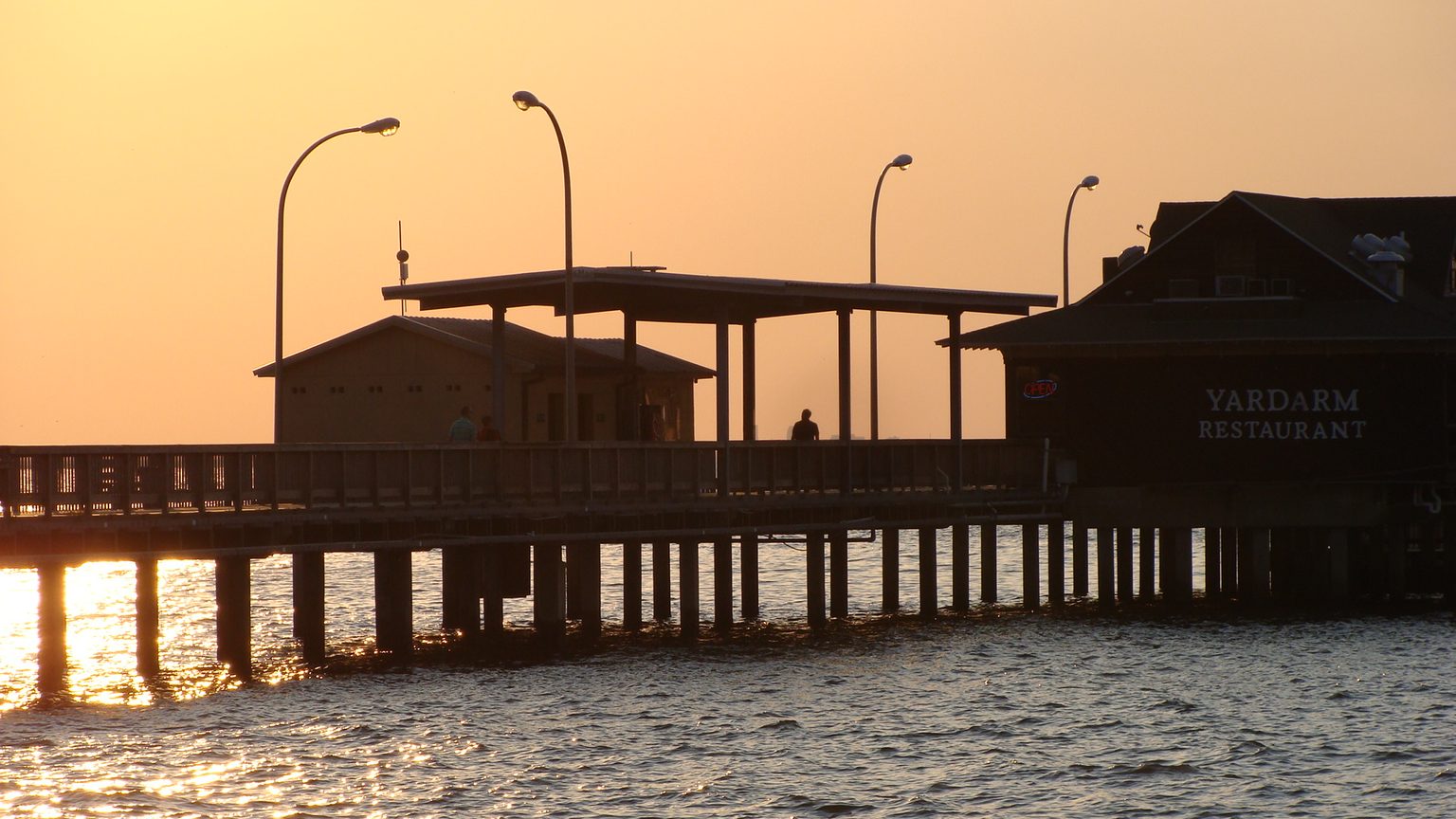 The iconic Fairhope Municipal Pier and rose garden at sunset on Mobile Bay
