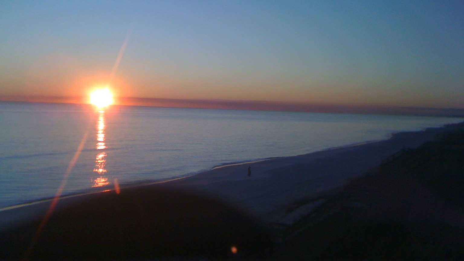 Rare coastal dune lake meeting the white sand beach and emerald Gulf in Santa Rosa Beach on 30A